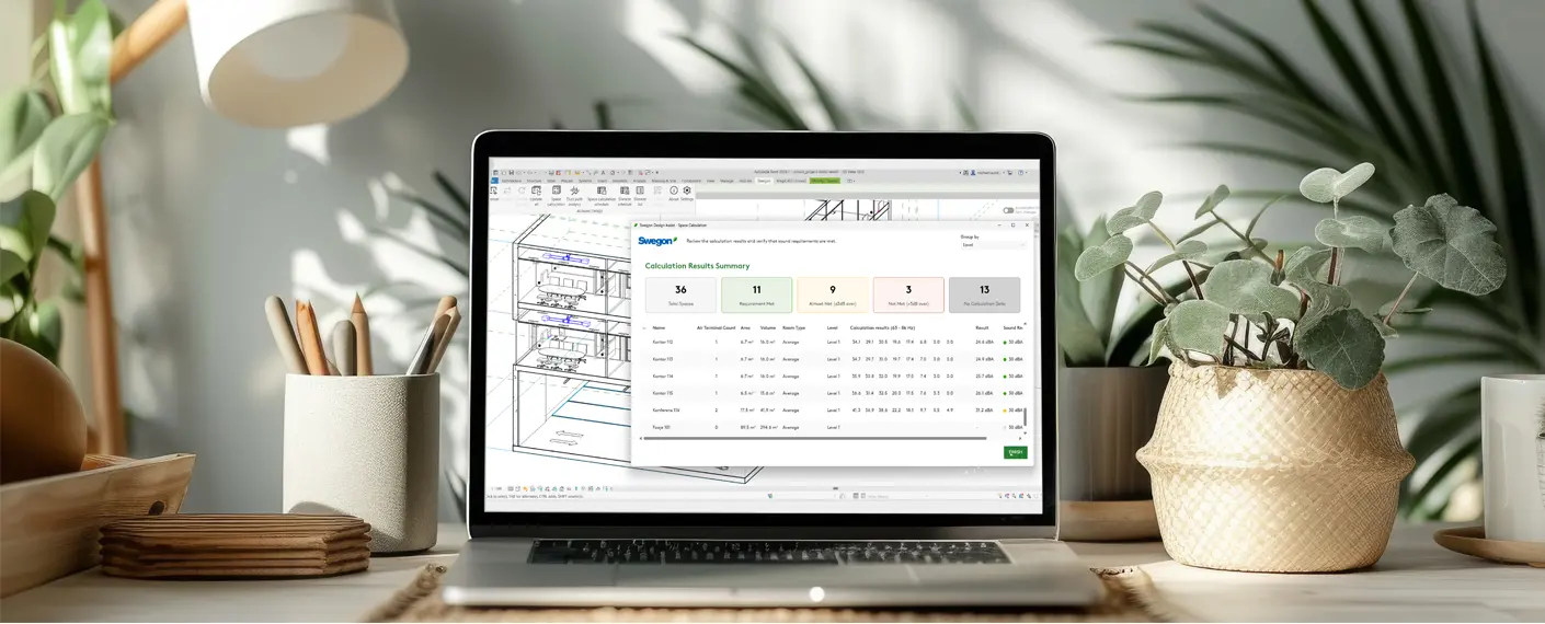 A laptop on a desk with plants, pens and other miscellaneous decor. The laptop screen is open and showing the plugin Design Assist.